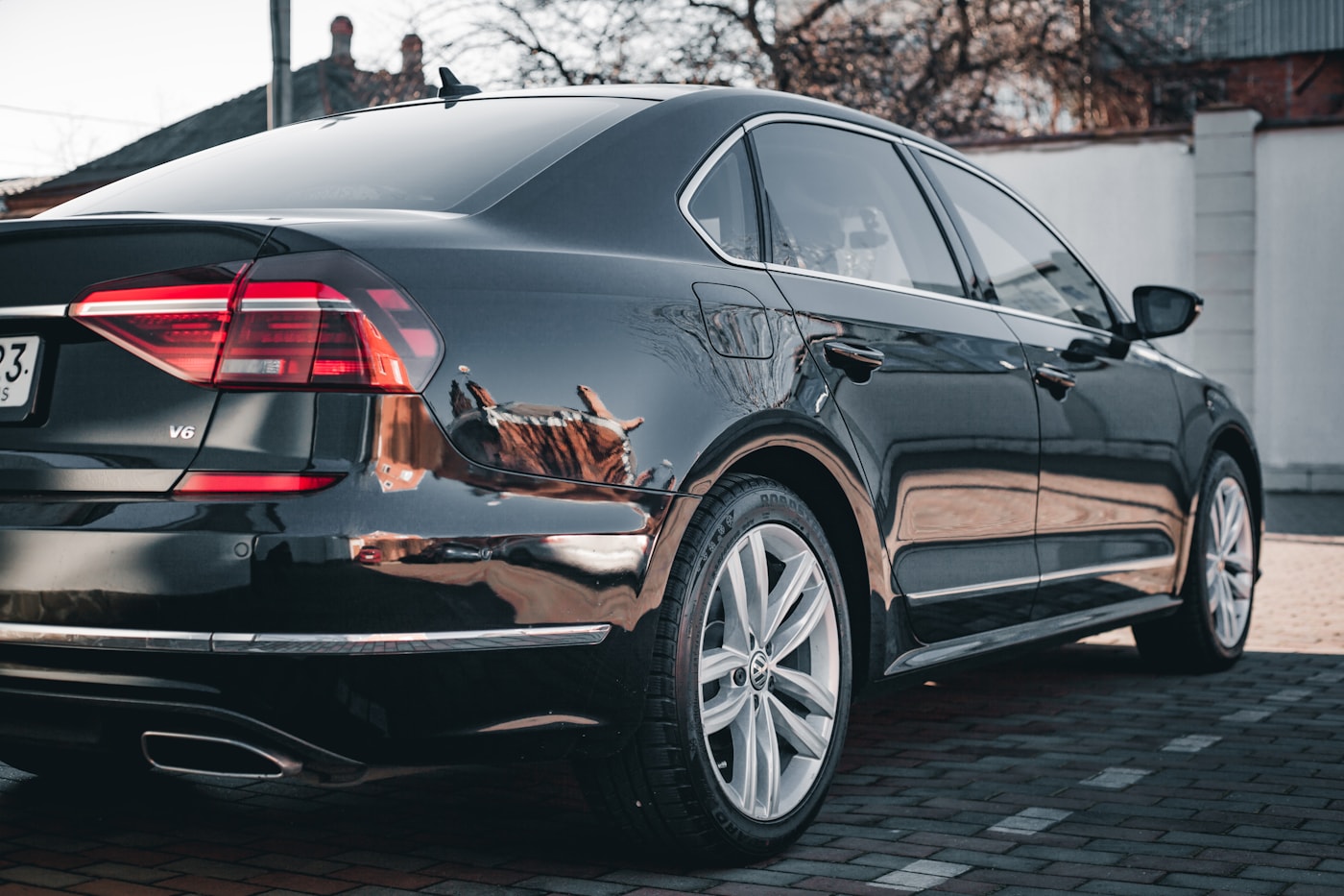 Black sedan rear quarter, mirror polish